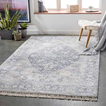 Styled room featuring the Laura Area Carpet in light gray and beige with a subtle bohemian pattern and fringe. Roomscene-Rectangle