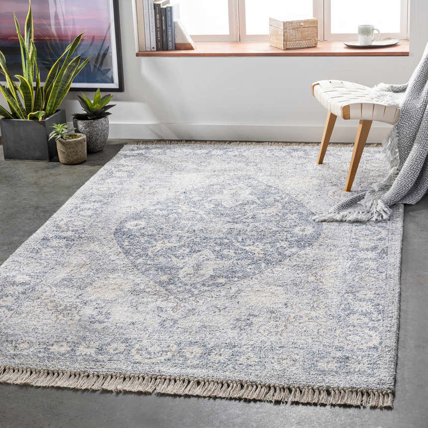 Styled room featuring the Laura Area Carpet in light gray and beige with a subtle bohemian pattern and fringe. Roomscene-Rectangle