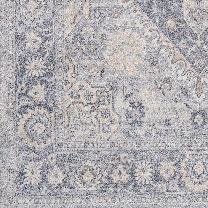 Close up of the Laura Area Carpet showing its beige, brown, and dark blue floral pattern and hand woven texture. Swatch