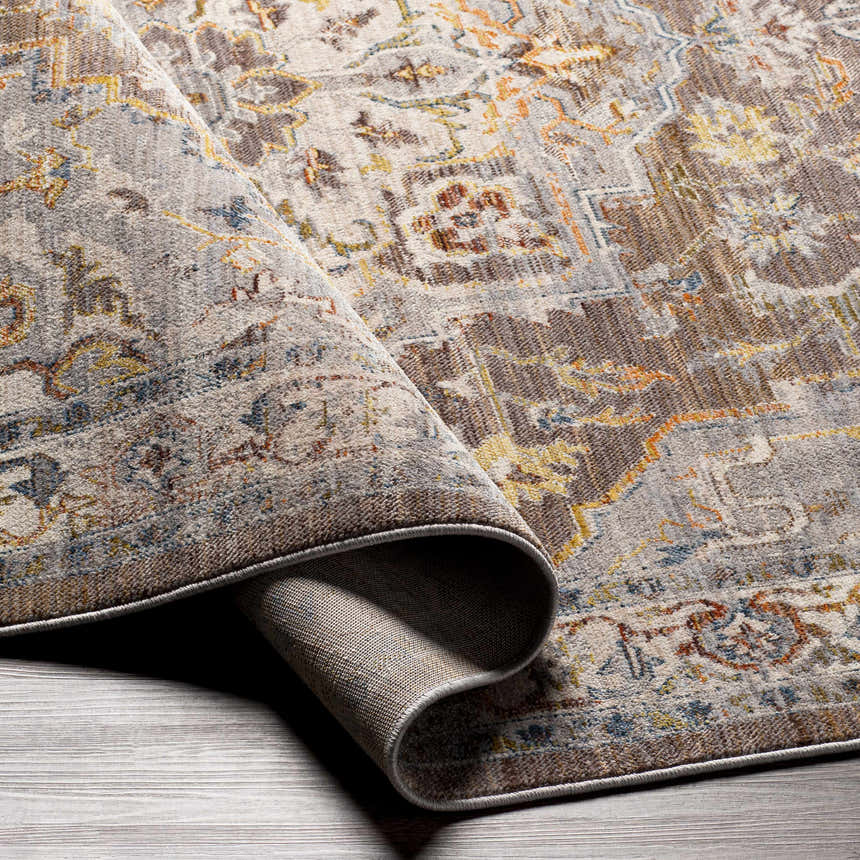Close-up of the LeChee Area Rug. Features a traditional design with brick red, orange, blue, and brown tones. Bohemian style. Fold