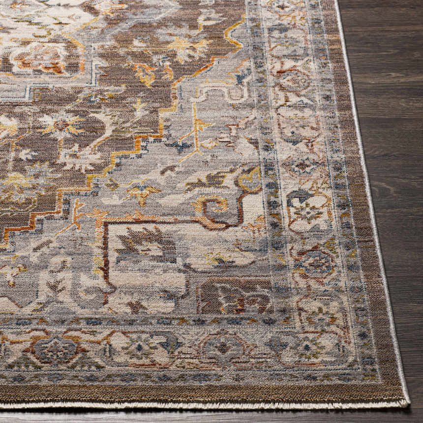 Close-up of the LeChee Area Rug. Bohemian style rug with brick red, burnt orange, and gray tones on dark wood floor. Front