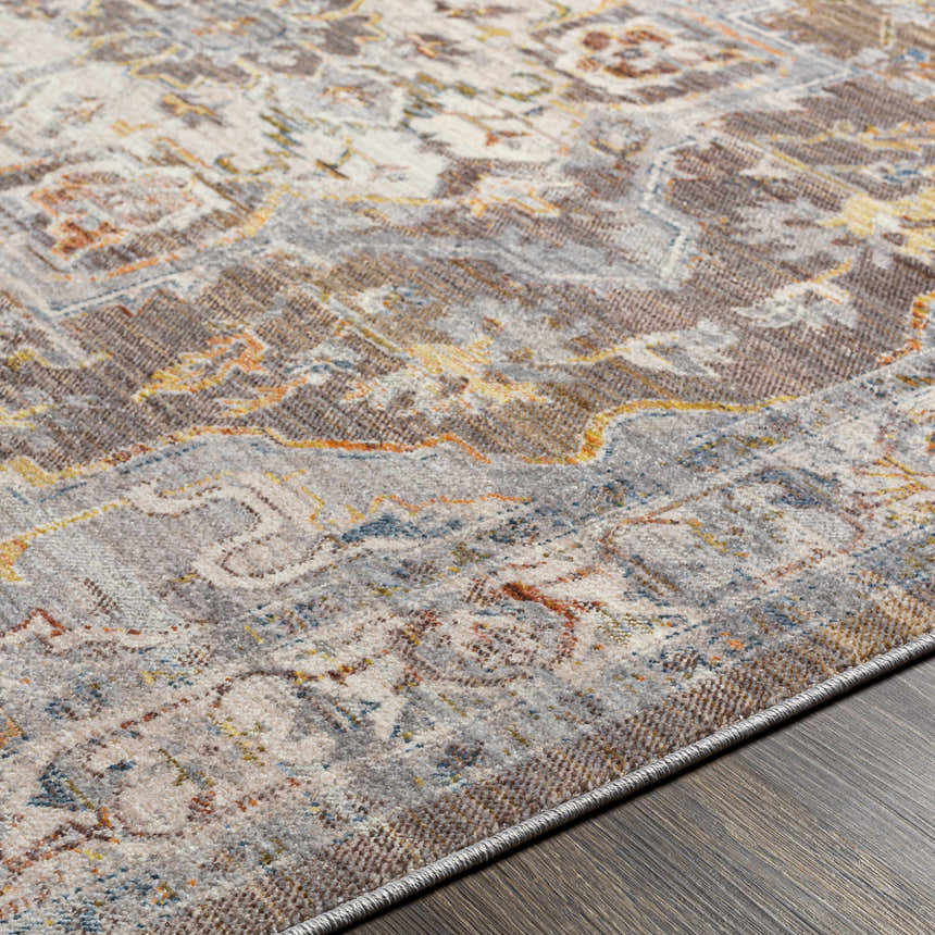 Close-up of the LeChee Area Rug, a machine-woven polyester rug with brick red, orange, and gray traditional patterns. Texture