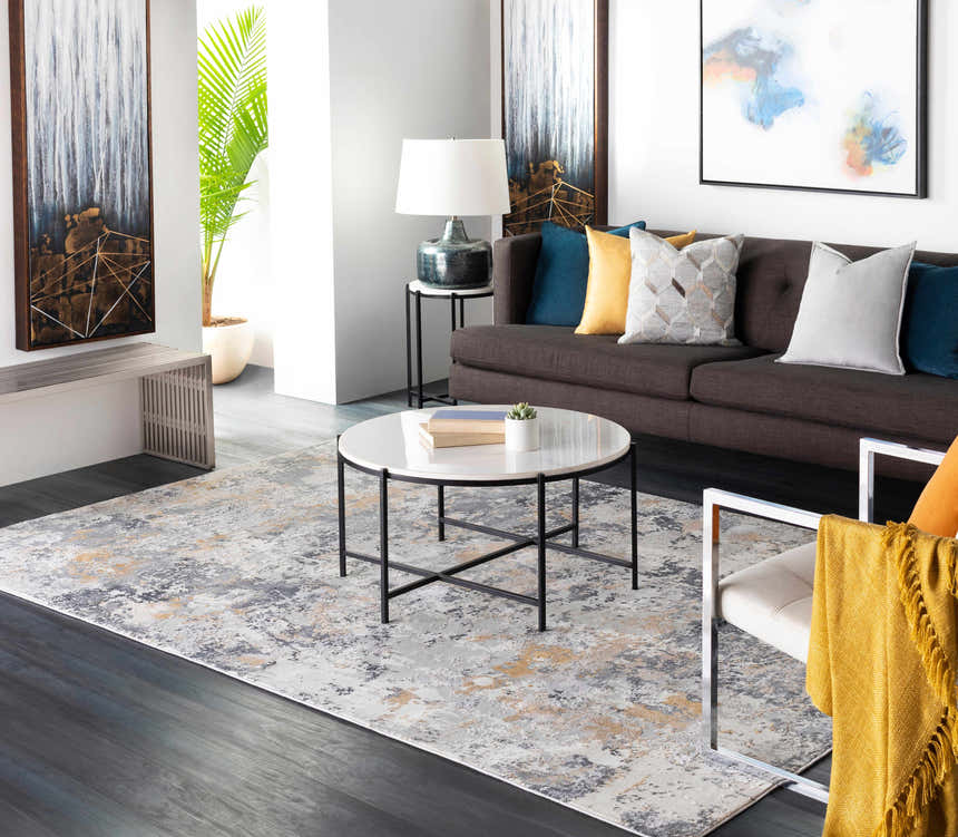 Living room scene with a Lenzburg Faux Silk Abstract Rug in charcoal, gray, and mustard under a round coffee table. Roomscene-Rectangle