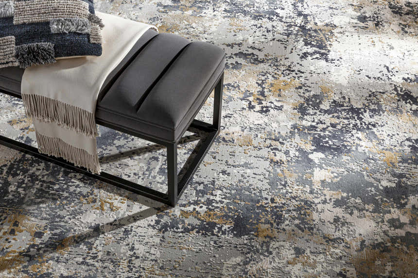 Styled Lenzburg Faux Silk Abstract Rug. Charcoal, gray, and mustard rug with a modern gray bench, throw, and pillow. Styleshot