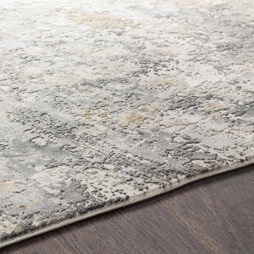 Close-up of the Lenzburg Faux Silk Abstract Rug. Charcoal, gray, and mustard tones with a subtle abstract pattern. Texture