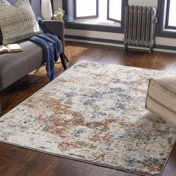 Living room scene with a brick red, cream, and denim Loughrea Area Rug, gray couch, and wood floors. Roomscene-Rectangle