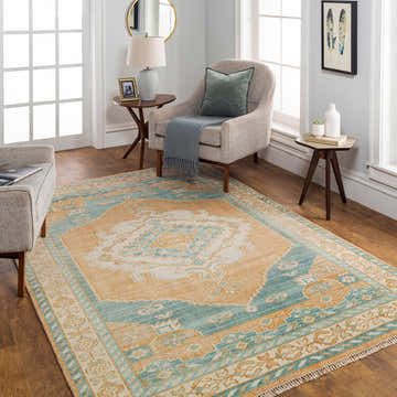 Living room scene with a blue and camel Ligayan Premium Rug, accent chair, and wood floors. Roomscene-Rectangle