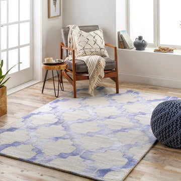 Living room scene with a denim and light gray Libby Area Rug, armchair, and blue pouf. Roomscene-Rectangle