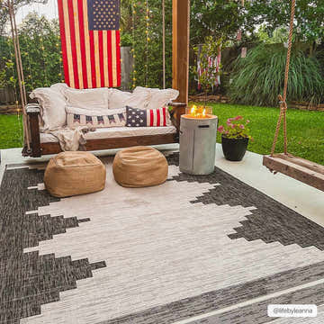 Patriotic porch with swing, fire pit, and black and white geometric Djugun Outdoor Rug. Roomscene-Rectangle