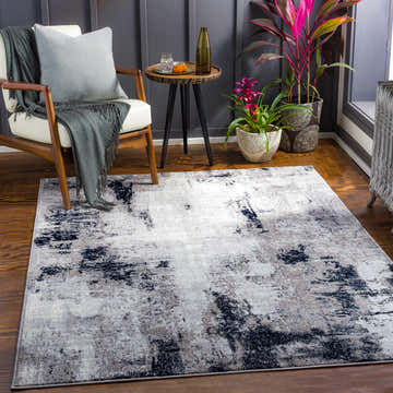 Living room scene with Limao Abstract Denim Area Rug, white chair, side table, and plants. Roomscene-Rectangle