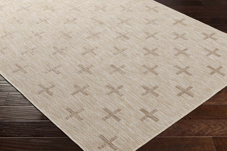 Close-up of Limbo Beige Outdoor Area Rug. Tan geometric plus sign pattern on cream polypropylene rug. Machine woven texture. Corner