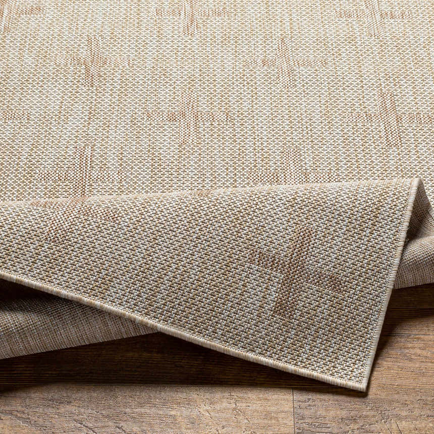 Close-up of the Limbo Beige Outdoor Area Rug showing woven texture and neutral colors on a wood floor. Fold