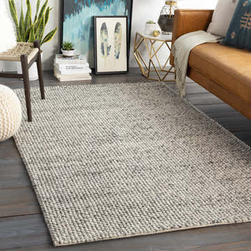 Living room scene with a charcoal and ivory Lucerne LNE-1001 Gray Wool Rug, leather couch, and modern decor. Roomscene-Rectangle