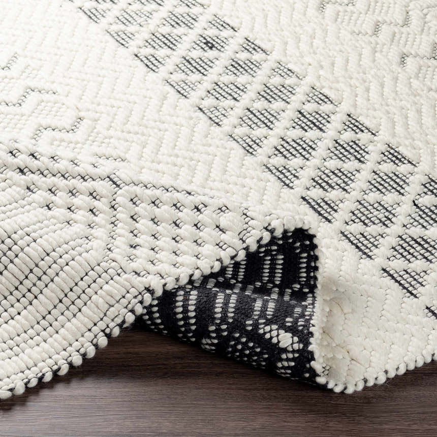 Close up of the hand woven Limoges Area Carpet. Black and cream geometric design in 100% wool. Fold