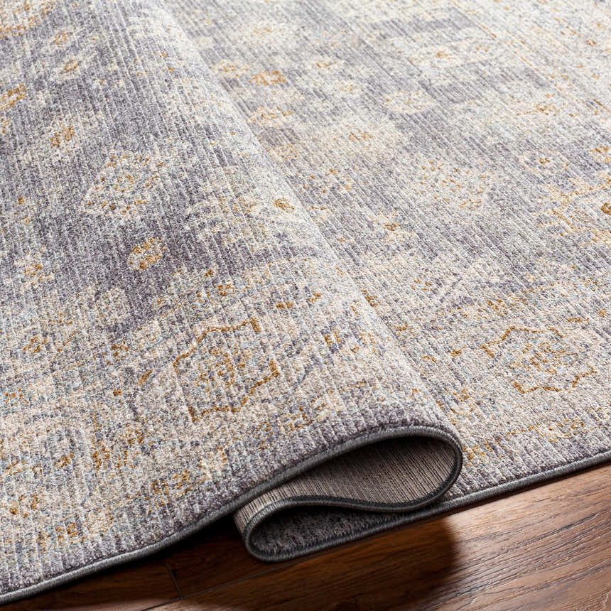 Close-up of Coby Brown Avant Garde rug showing its luxe texture, traditional pattern, and colors: gray, charcoal, and dusty sage. Fold