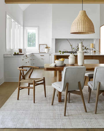 Farmhouse dining room with a wood table, chairs, and the Lubna Ivory Area Rug in light silver. Roomscene-Rectangle