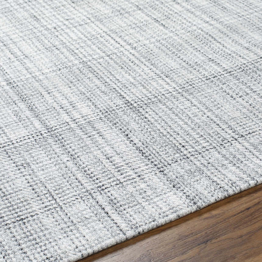 Close-up of the hand woven Lubna Light Slate Area Rug. Black, charcoal, and light slate hues create a subtle plaid pattern. Texture
