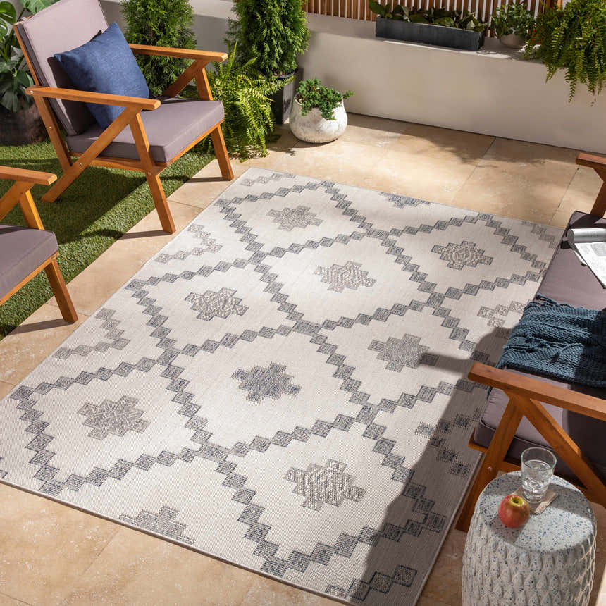 Outdoor patio scene with Lanigan Indoor & Outdoor Rug, wooden chairs, plants, and tile flooring. Contemporary Southwestern style. Roomscene-Rectangle