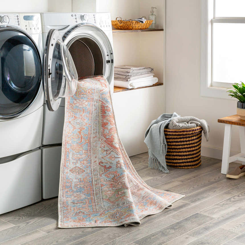 Laundry room scene with Rust Maayon Washable Rug coming out of a front load washing machine. Easy clean rug. Washing-Machine