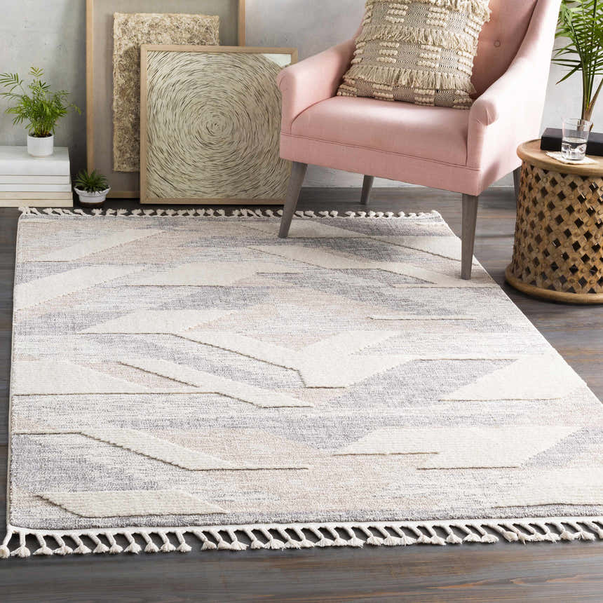 Styled room featuring Magazine Geometric High/Low Pile Rug with Tassels in gray and tan. Pink chair and wood accents. Roomscene-Rectangle