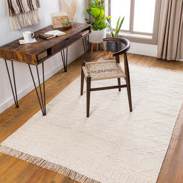 Home office with wood desk, chair, and light beige Manby Area Rug with geometric pattern and fringe. Roomscene-Rectangle