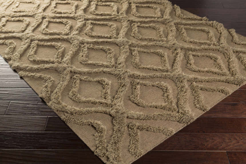 Close-up of the brown Manorville Area Rug showing its geometric shag design and texture on dark wood floors. Corner