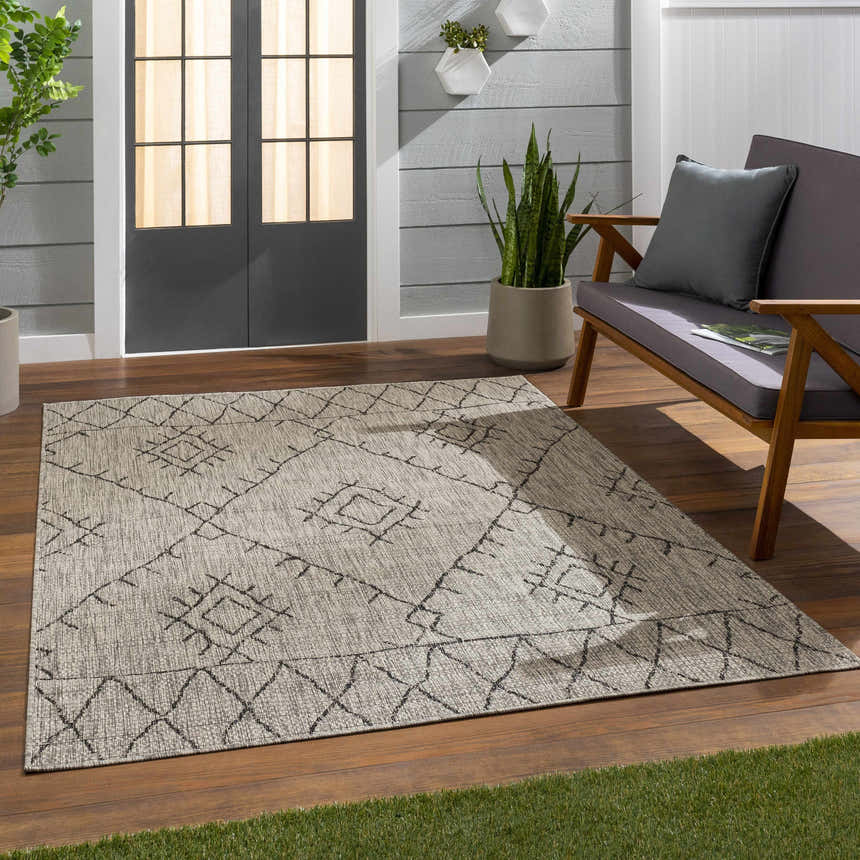 Outdoor patio scene with a taupe Marwood Nordic Performance Rug, gray loveseat, and wood flooring. Roomscene-Rectangle