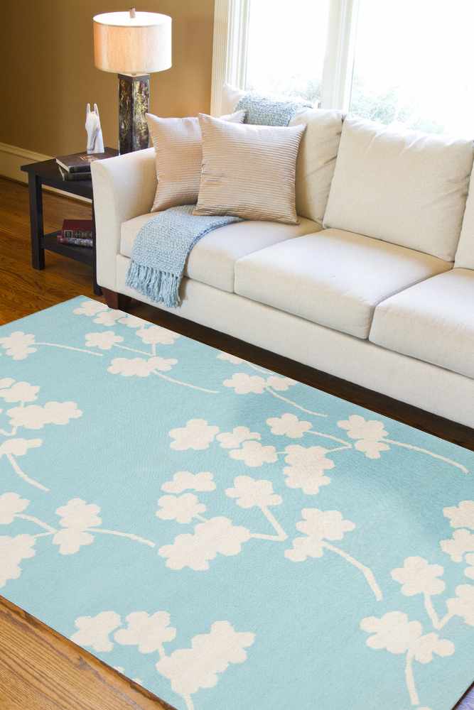 Living room scene with a light beige sofa and aqua Matador Area Carpet featuring a floral design. Roomscene-Rectangle