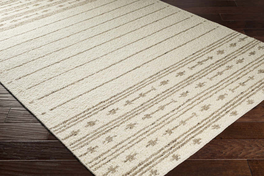 Close-up of the ivory Matawan Premium Wool Rug with a brown striped and floral pattern on dark wood flooring. Corner