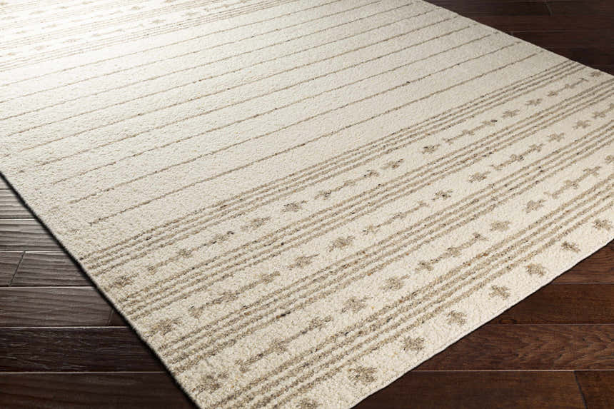 Close-up of Matawan Premium Wool Rug in cream and taupe with striped and geometric pattern. Hand woven texture. Corner