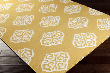 Close-up of the Mattoon Area Rug. Mustard yellow wool rug with off-white geometric pattern. Hand woven texture. Corner