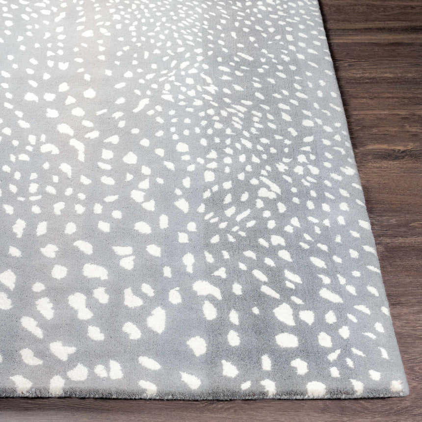 Close-up of the Athena Gray Giraffe Print Wool Rug showing its gray and cream animal pattern and hand-tufted texture. Front