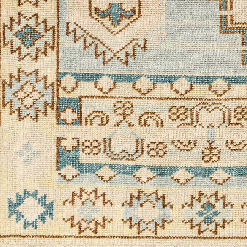 Close-up of McColl Hand Knotted Wool Blend Rug with traditional brown, cream, and teal geometric patterns. Swatch