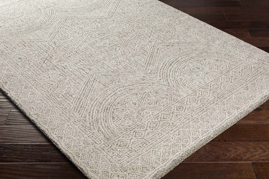 Close-up of the Middleville Luxe Rug. Contemporary style rug in charcoal, cream, and light beige with geometric patterns. Corner