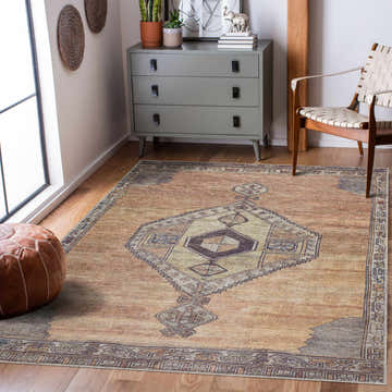 Living room scene with a Medinah Washable Area Rug in brown, camel, and ivory, styled with a grey dresser and leather pouf. Roomscene-Rectangle