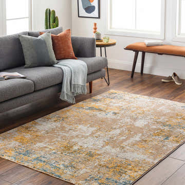Living room scene with Meads Abstract Mustard Luxe Rug, gray sofa, and wood floors. Roomscene-Rectangle