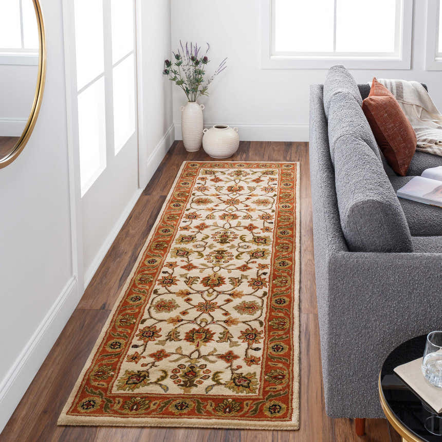 Living room scene with a beige, red, and brown Medaryville Area Rug runner, gray sofa, and wood floors. Roomscene-Runner
