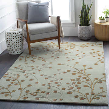 Living room scene with a Sage Elsu Area Rug, gray chair, side tables, and plants. Floral pattern rug in sage and brown. Roomscene-Rectangle