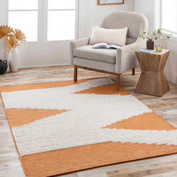 Living room scene with Milagros Area Rug in cinnamon and cream. Bohemian rug styled with gray chair and wood side table. Roomscene-Rectangle