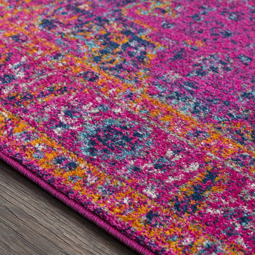 Close-up of the Milliken Magenta Area Rug, showcasing its burgundy, orange, navy, and teal bohemian pattern. Texture