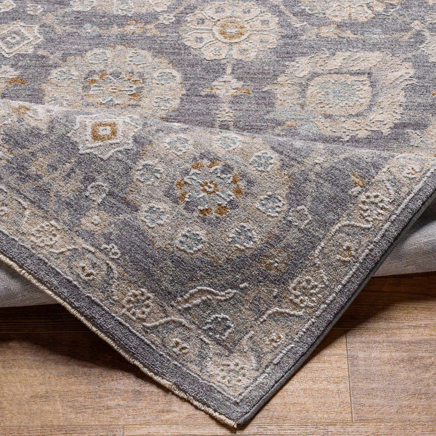 Close-up of the Mimarsinan Thick Luxe Statement Rug showing its gray, beige, and brown oriental pattern and soft texture. Fold