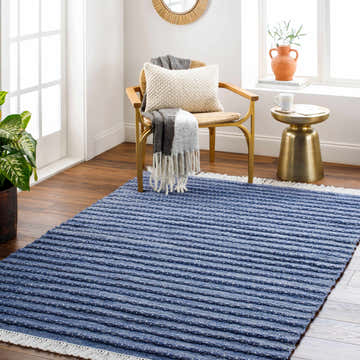 Living room scene with blue striped Mala Area Rug, gold accent table, and cozy chair. Roomscene-Rectangle