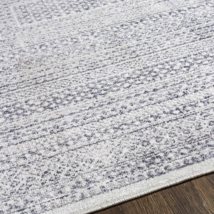 Close-up of the Mandaon Area Rug, a machine-woven rug with a charcoal, cream, and gray bohemian pattern. Texture