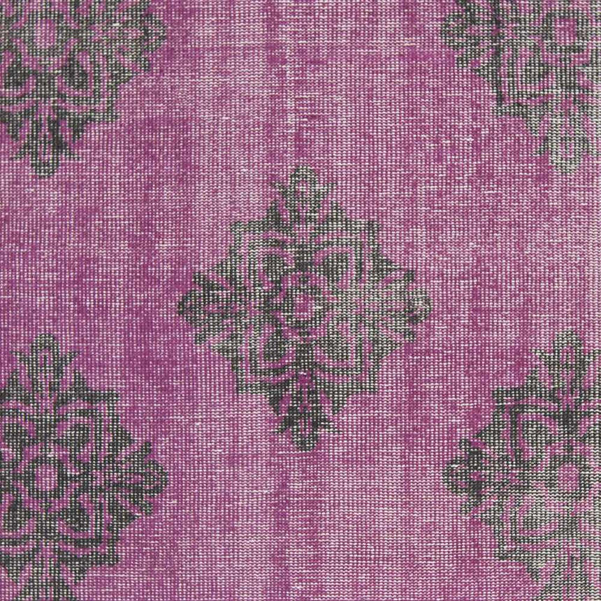 Close-up of the Mina Area Rug. Hand-knotted wool rug in fuchsia with a black diamond pattern. Swatch