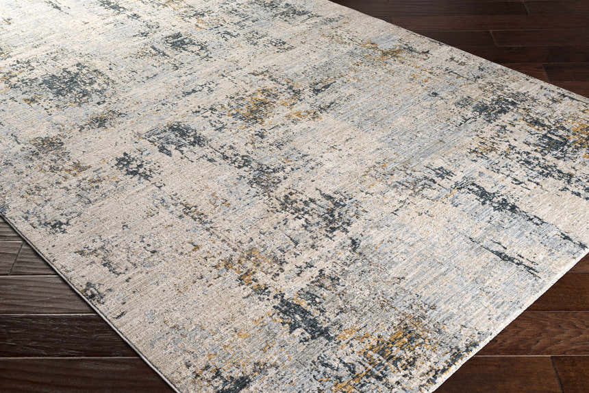 Close-up of the Montreat Luxe Rug, a cream, gray, and mustard abstract pattern on dark wood floors. Corner