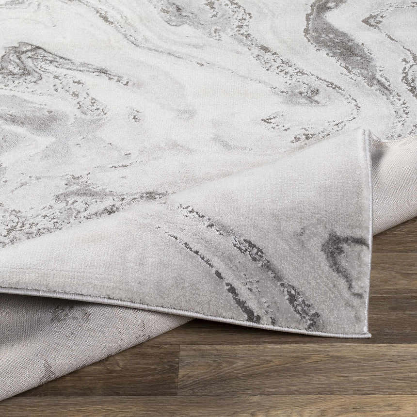Close-up of the Moana Charcoal Marble Rug, showcasing its gray and white marble-like pattern and soft texture. Fold