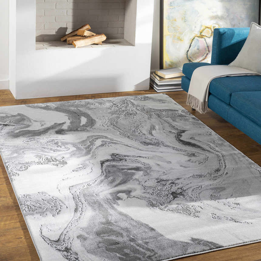 Living room scene with a blue sofa and the Moana Charcoal Marble Rug in charcoal, gray, and white. Roomscene-Rectangle