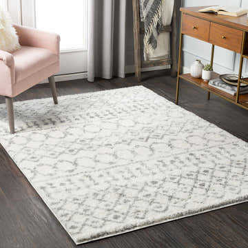 Living room scene with a cream and gray Monarch Area Rug, pink chair, and wood accents. Roomscene-Rectangle