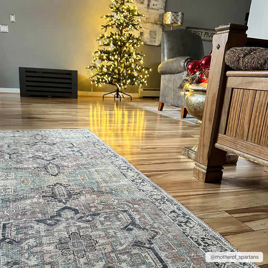 Living room scene with a Christmas tree and the Green Nisa Tumble Dry Washable Rug on a wood floor. Roomscene-Rectangle