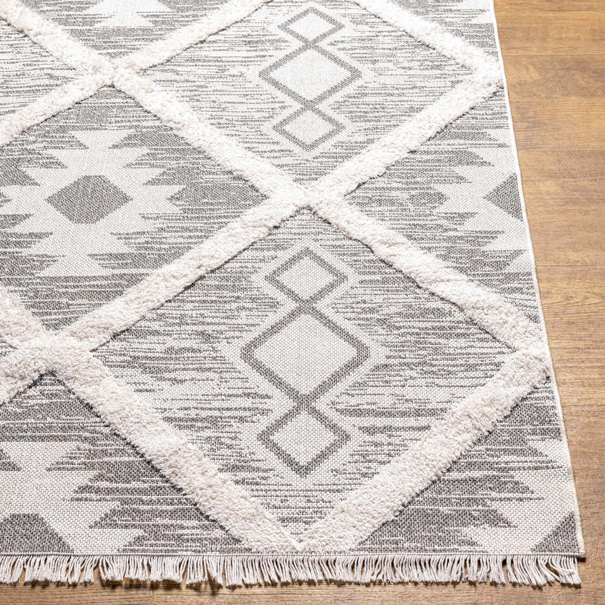 Close-up of the Moto Area Rug featuring a gray and white Southwestern diamond pattern and fringe. Front